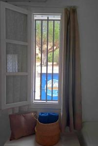 une fenêtre avec vue sur la piscine dans l'établissement Georgia Rooms Milos, à Plaka Milou
