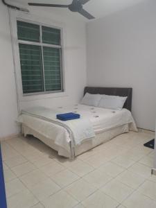 ein Schlafzimmer mit einem Bett in einem Zimmer mit einem Fenster in der Unterkunft Homestay MdmMai Private Pool in Masjid Tanah