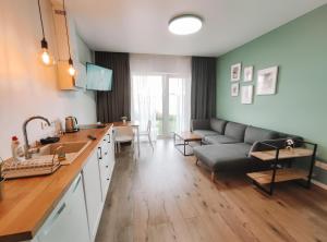 K-Town - Apartments ViaBaltic Kaunas في كاوناس: مطبخ وغرفة معيشة مع أريكة وطاولة
