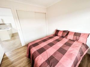 a bedroom with a bed with a checkered blanket at Stay at Mandi’s in Kingston