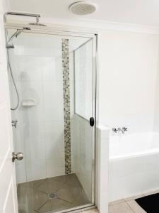 a shower with a glass door in a bathroom at Stay at Mandi’s in Kingston