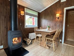 uma lareira num quarto com uma mesa e um fogão em Harekroken em Tynset