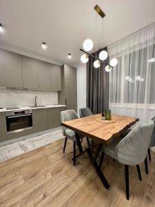 a kitchen and dining room with a wooden table and chairs at Vanquish Central Apartment in Varna City