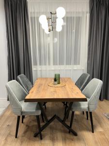 a dining room table with chairs and a light fixture at Vanquish Central Apartment in Varna City +41 photos
