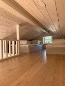 Großes Zimmer mit 2 Betten und einer Holzdecke. in der Unterkunft Lyxiga stugor med sjöutsikt in Söderköping
