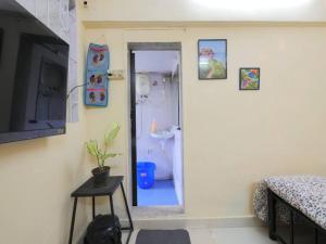 a room with a bathroom with a toilet and a television at DawnsMelody in Mumbai