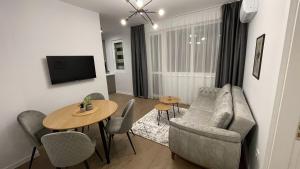a living room with a couch and a table at Vanquish Central Apartment in Varna City