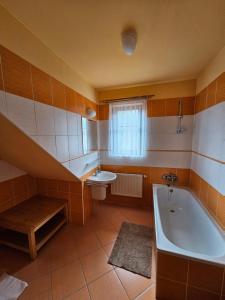 duża łazienka z wanną i umywalką w obiekcie Horský Hotel Sněženka w mieście Hynčice pod Sušinou