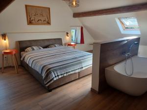 a bedroom with a bed and a bath tub at de ploeg luxe in Bullange