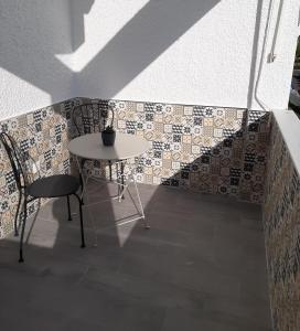 a table and chair next to a wall with tiles at Apartamento Rota in Rota +2 photos