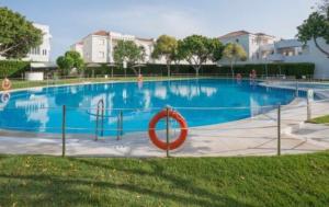 a large swimming pool with a red sign in front of it at Apartamento Rota in Rota