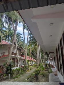 Une rangée de palmiers à côté d'un bâtiment dans l'établissement Crossbill Beach Resort, à Havelock Island