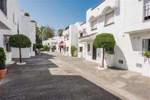 una calle adoquinada en una ciudad con edificios blancos en Escape to Serenity - 3 Bedroom Townhouse by the Sea!, en Marbella