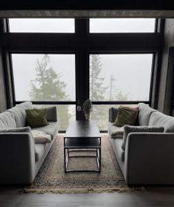 a living room with two couches and a coffee table at Stylish cabin at Lifjell with jacuzzi and sauna in Bø
