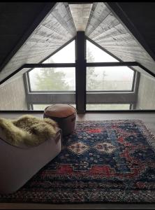 a living room with a large window and a rug at Stylish cabin at Lifjell with jacuzzi and sauna in Bø