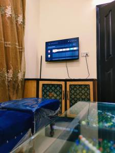 a room with a couch and a tv on a wall at 2 bedrooms house for families in Lahore