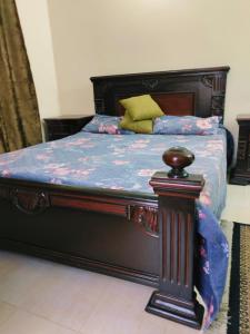 a bedroom with a bed with a wooden frame at 2 bedrooms house for families in Lahore