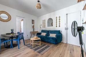ein Wohnzimmer mit einem blauen Sofa und einem Tisch in der Unterkunft MBA Splendide Appart - Diderot 1 - Proche de Nation in Montreuil
