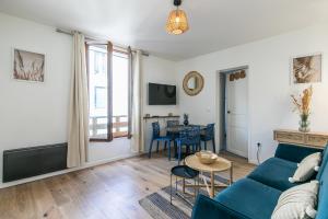 uma sala de estar com um sofá azul e uma mesa em MBA Splendide Appart - Diderot 1 - Proche de Nation em Montreuil