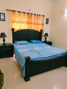 a bedroom with a bed with a blue comforter at 2 bedrooms house for families in Lahore