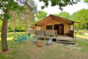 una tienda con dos bicicletas estacionadas frente a ella en Camping Etang de la Vallée, en Combreux