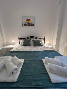 a bedroom with a bed with towels on it at Sunny Peraia Apartment in Perea +3 photos