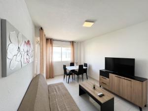 a living room with a television and a table at Espacio ideal en la Playa in Oropesa del Mar