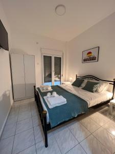 a bedroom with a large bed with towels on it at Sunny Peraia Apartment in Perea