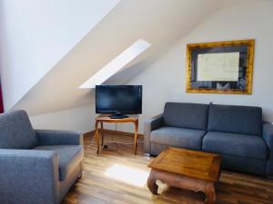 a living room with two couches and a tv at Hotel Weinhaus Hoff in Bad Honnef am Rhein