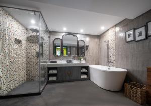 a bathroom with a tub and a sink and a shower at Hotel Cote Cour Beijing in Beijing