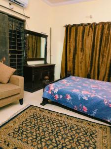 a bedroom with a bed and a mirror and a couch at 2 bedrooms house for families in Lahore