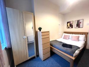 ein Schlafzimmer mit einem Bett mit einer Kommode und einem Schrank in der Unterkunft Russell House in Liverpool