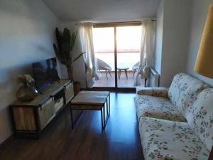 uma sala de estar com um sofá, uma televisão e uma mesa em Apartamentos casa memé em Mora de Rubielos
