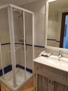 een badkamer met een douche, een wastafel en een spiegel bij Apartamentos casa memé in Mora de Rubielos