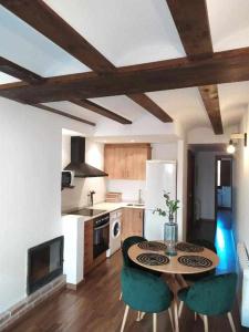 uma cozinha com uma mesa e cadeiras numa cozinha em Apartamentos casa memé em Mora de Rubielos