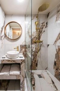 een badkamer met een douche met wastafel en spiegel bij Bon Marche - Charming apartment in Parijs +12 foto's