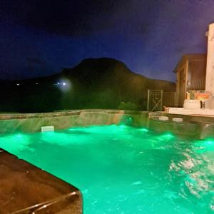 una piscina por la noche con luces azules en Glens glamping, en Cushendall