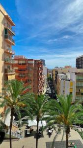 a group of palm trees in a city with buildings at Azul Cómodo, bonito y céntrico in Calpe