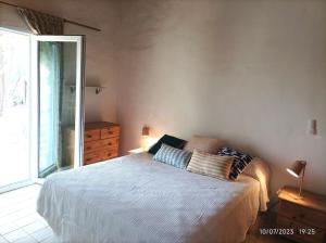 a bedroom with a bed and a large window at Casa rural con piscina in Torre de Benagalbón