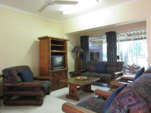 a living room with a couch and a tv at Luwandla 12 in St Lucia