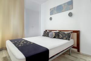 a small bedroom with a bed with white sheets and pillows at Azul Cómodo, bonito y céntrico in Calpe