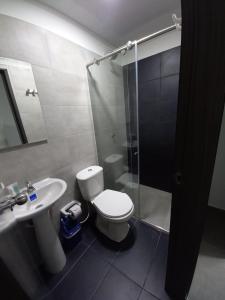 y baño con aseo, lavabo y ducha. en Hotel Olam Confort, en Villavicencio