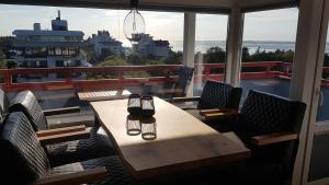 a table and chairs on a balcony with a view of a ship at LITTLE SKYSUITE Terrassenhaus W 94 in Cuxhaven