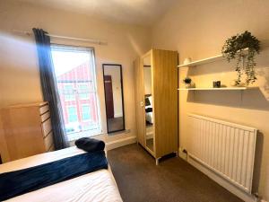 ein Schlafzimmer mit einem Bett und einem großen Fenster in der Unterkunft Russell House in Liverpool