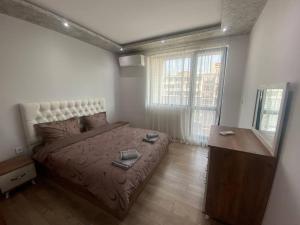 a bedroom with a bed and a dresser and window at Cozy-1BD Flat in Plovdiv