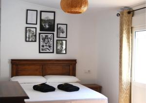 a bedroom with a bed with black and white pictures on the wall at Casa Rural Relax & Nature in Prado del Rey