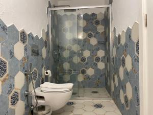 ein Badezimmer mit Toilette und Glasdusche in der Unterkunft Adacan Hotel Alaçatı in Alacati + 21 Fotos