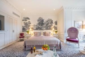a bedroom with a bed and two chairs at Hôtel Hermitage Monte-Carlo in Monte Carlo