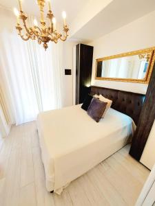 a bedroom with a bed with a mirror and a chandelier at Piccolo Mondo Verona in Verona