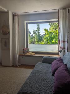 1 dormitorio con ventana, sofá y asiento junto a la ventana en Wohnung mit Terrasse und eigenem Parkplatz en Nabburg